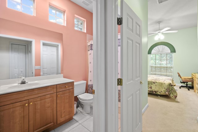 bathroom featuring tile patterned floors, toilet, vanity, ceiling fan, and a towering ceiling