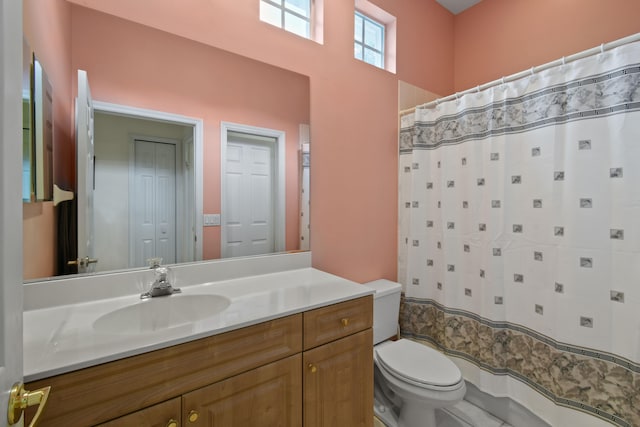 bathroom featuring vanity, toilet, and curtained shower