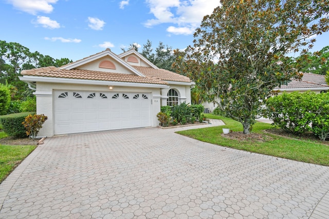 view of front of home with a tile roof, decorative driveway, a garage, and stucco siding