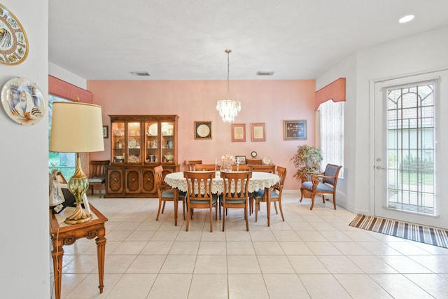 dining room with light tile patterned floors and an inviting chandelier