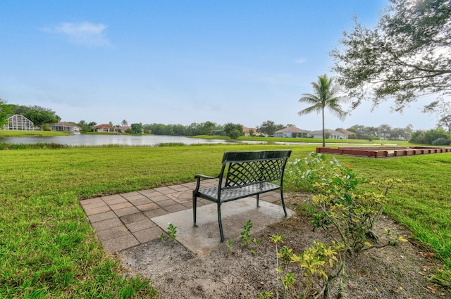 view of home's community with a lawn, a patio, and a water view