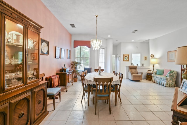 tiled dining room featuring a textured ceiling and an inviting chandelier