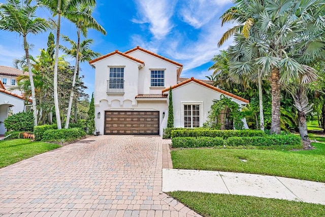 mediterranean / spanish-style home featuring a garage and a front yard