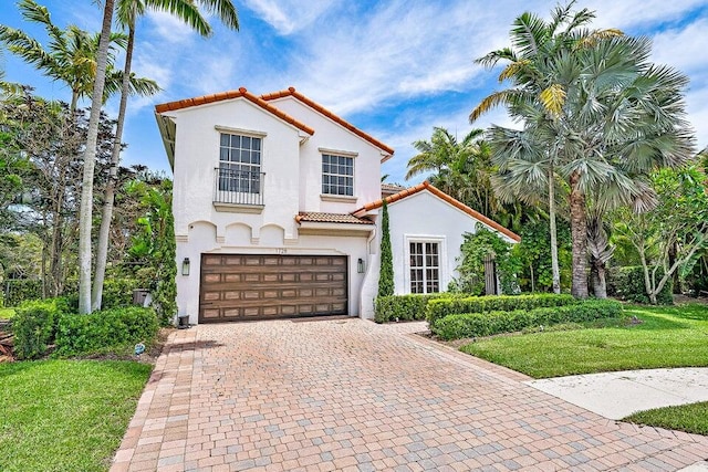 mediterranean / spanish-style house with a garage and a front lawn