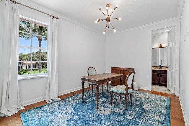 dining room with light wood-type flooring, crown molding, sink, and a notable chandelier