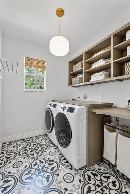 laundry room with a textured ceiling and separate washer and dryer