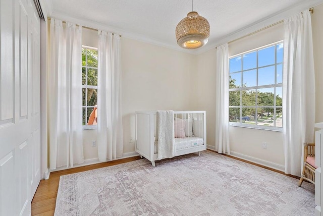 unfurnished bedroom featuring ornamental molding, a textured ceiling, and light hardwood / wood-style flooring