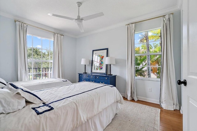 bedroom featuring ceiling fan, light wood-type flooring, and multiple windows