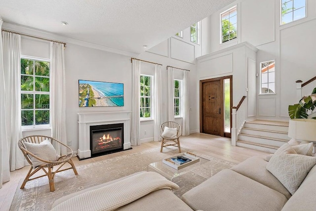 living room featuring plenty of natural light, a textured ceiling, and light hardwood / wood-style flooring