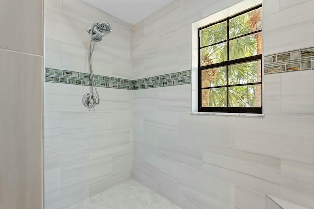 bathroom featuring a wealth of natural light and a tile shower