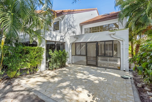 rear view of property featuring a sunroom