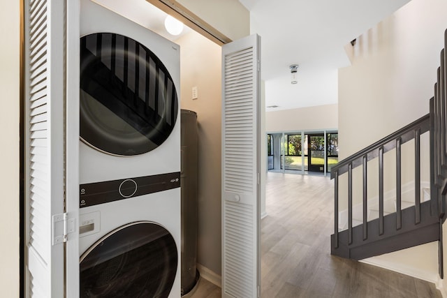 laundry area featuring dark hardwood / wood-style floors and stacked washing maching and dryer