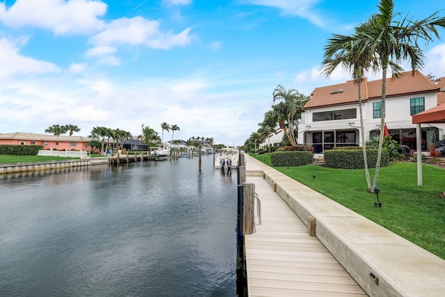 dock area with a water view and a lawn