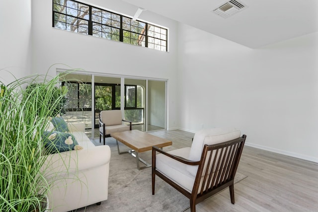 interior space with a towering ceiling and light hardwood / wood-style flooring