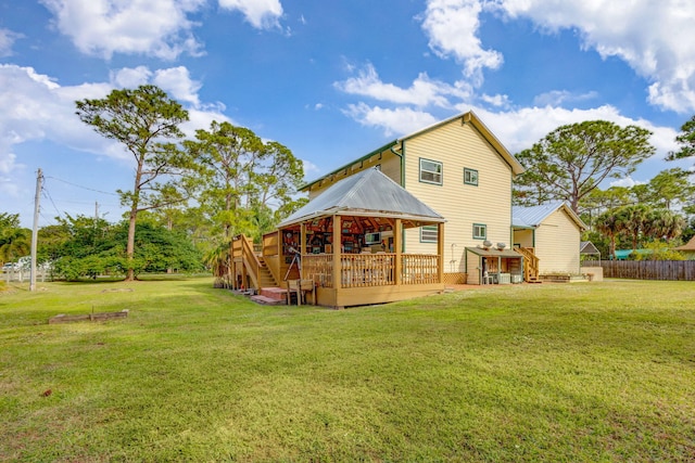 rear view of property featuring a deck and a lawn