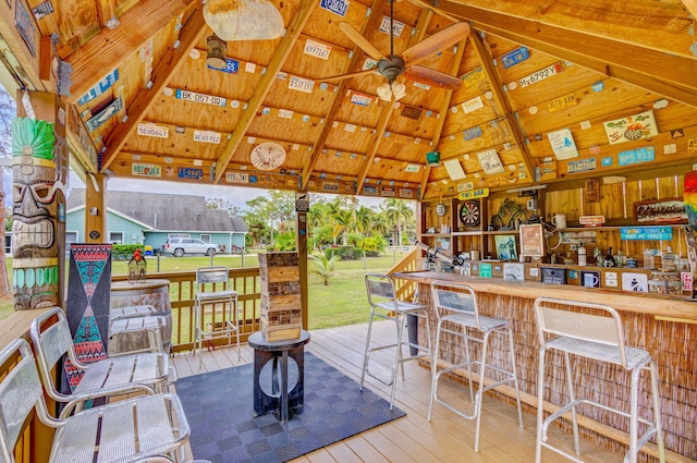 wooden terrace with a gazebo, ceiling fan, and exterior bar