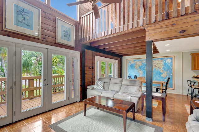 living room featuring light tile patterned floors, a high ceiling, a wealth of natural light, and french doors