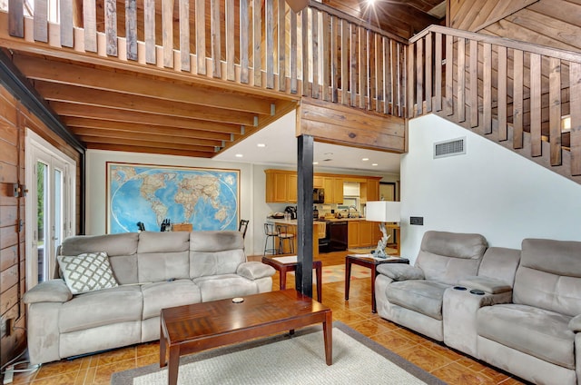 living room featuring light tile patterned flooring, a towering ceiling, and sink