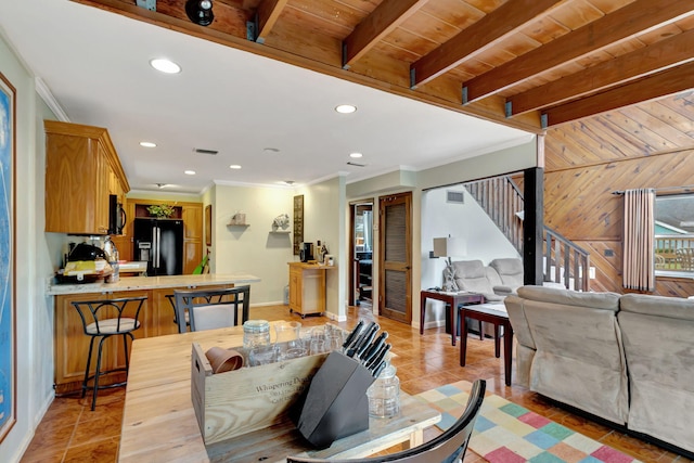 tiled living room featuring beam ceiling, wood walls, crown molding, and wood ceiling