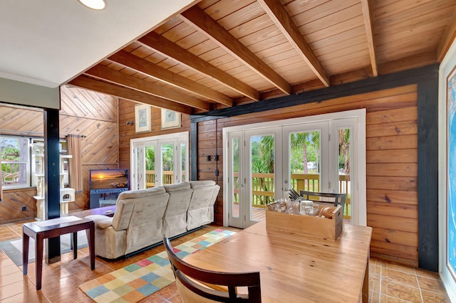 living room with french doors, beam ceiling, wooden walls, and wood ceiling