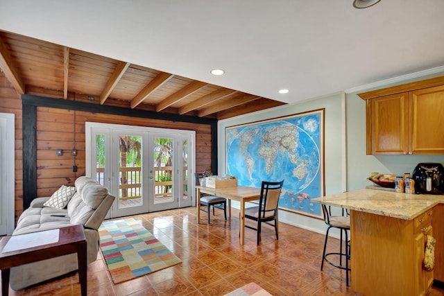 dining area with light tile patterned flooring, wood ceiling, wooden walls, and french doors