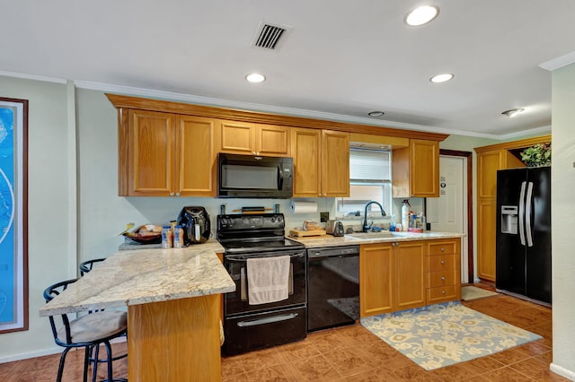 kitchen with sink, kitchen peninsula, crown molding, a kitchen bar, and black appliances