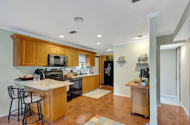 kitchen with a breakfast bar, black appliances, sink, ornamental molding, and light stone counters