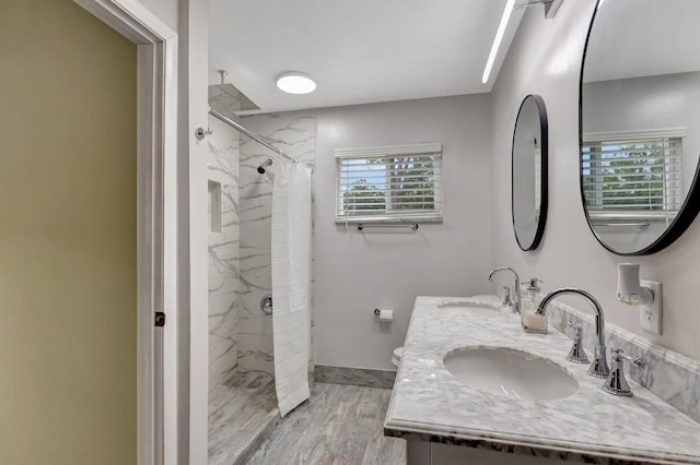 bathroom with plenty of natural light, hardwood / wood-style floors, and tiled shower