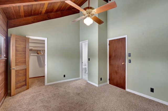 unfurnished bedroom with light colored carpet, a spacious closet, ceiling fan, and wood ceiling