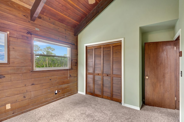 unfurnished bedroom with vaulted ceiling with beams, light colored carpet, and a closet