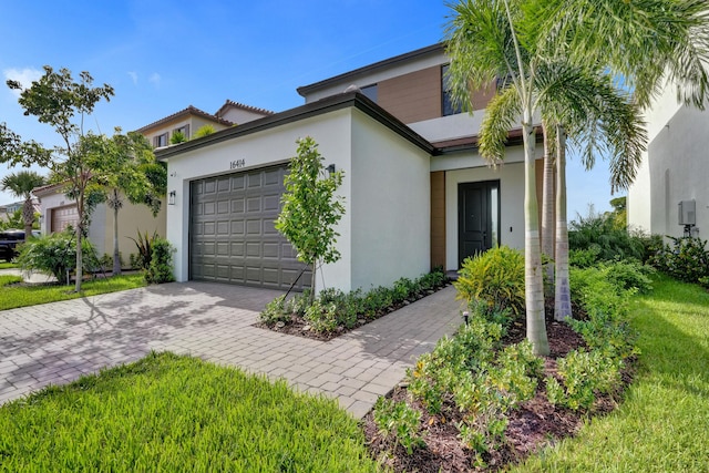 view of front of house featuring a garage, decorative driveway, and stucco siding