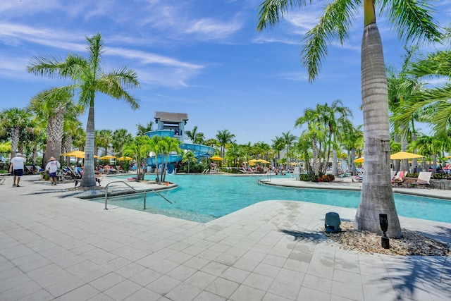 view of pool with a water slide and a patio area