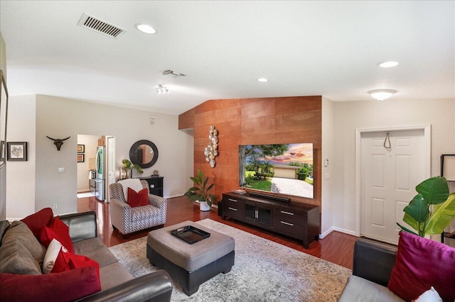 living room featuring vaulted ceiling and hardwood / wood-style flooring