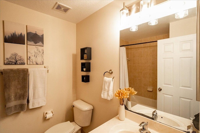 bathroom with vanity, toilet, and a textured ceiling