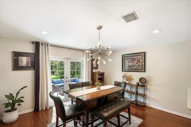 dining space featuring a chandelier, dark hardwood / wood-style flooring, a textured ceiling, and french doors