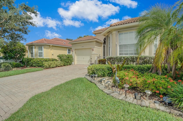 mediterranean / spanish home with a garage and a front yard