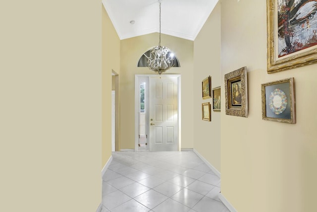 entrance foyer featuring lofted ceiling, ornamental molding, a chandelier, and light tile patterned flooring