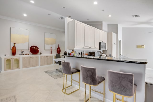 kitchen featuring light tile patterned flooring, crown molding, and kitchen peninsula