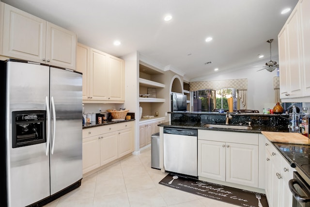 kitchen featuring ceiling fan, light tile patterned floors, white cabinetry, appliances with stainless steel finishes, and crown molding