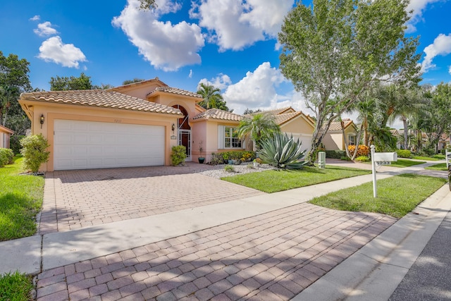 mediterranean / spanish-style house with a front yard and a garage