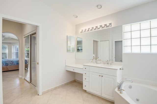 bathroom with vaulted ceiling, a tub, tile patterned floors, ceiling fan, and vanity