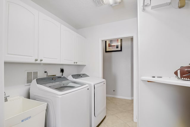 laundry room featuring washing machine and dryer, light tile patterned flooring, sink, and cabinets