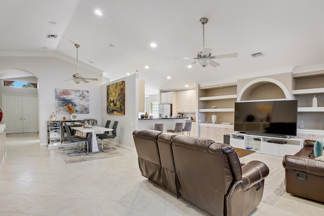 tiled living room with ceiling fan, lofted ceiling, and ornamental molding