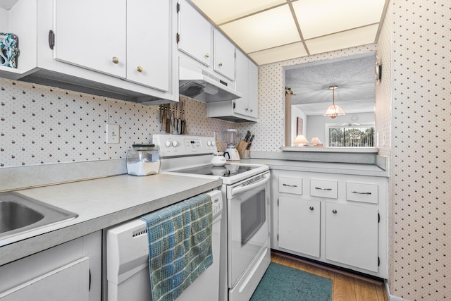 kitchen with white electric range, under cabinet range hood, light countertops, wood finished floors, and white cabinets