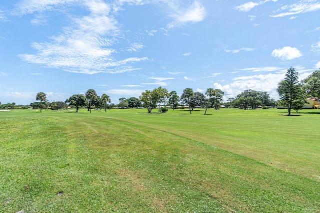 surrounding community with a yard and golf course view