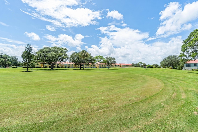 view of green lawn featuring golf course view