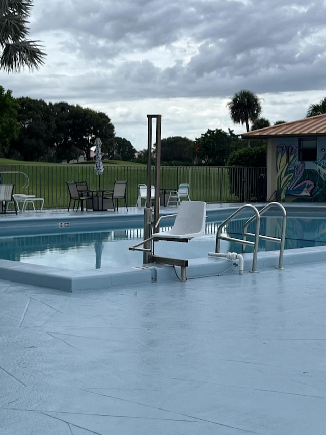 community pool featuring fence and a patio area