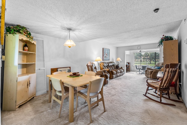 dining space featuring a textured ceiling and light colored carpet