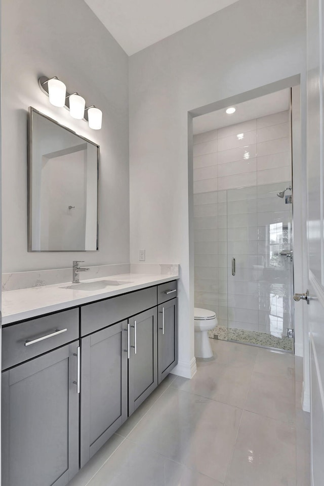 bathroom with walk in shower, vanity, toilet, and tile patterned flooring