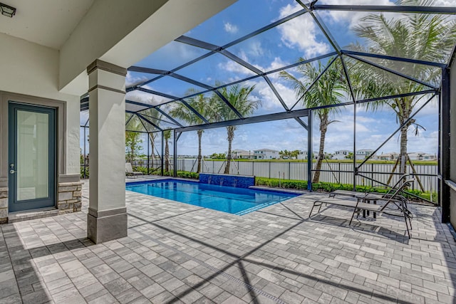 view of pool with a patio, pool water feature, and glass enclosure